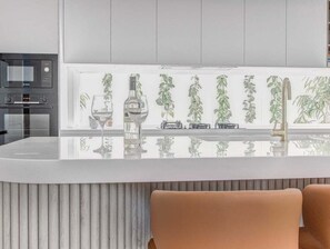 Een moderne keuken met een centraal eiland, een magnetron en een inbouwoven.