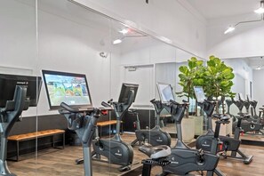 A gym with stationary bikes, a bench, and a large mirror. - Skyline-View, 2BR, 2.5Bt, Pool, Gym& Free Parking (Dallas)