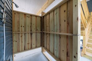 Een hoek van een kamer met houten wandbekleding en een stalen balkenconstructie.