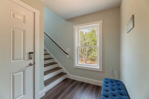 A staircase leading to a landing with a view of trees outside. - The Fourth Watch - 4x4 Carova Beach, Ocean View, Brand New, Linens, Flex Stays (Carova Beach)