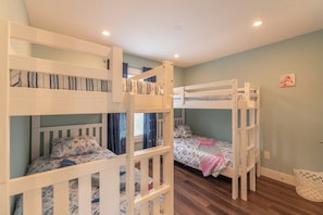 A room with bunk beds, a window with curtains, and a wall with a small picture. - The Fourth Watch - 4x4 Carova Beach, Ocean View, Brand New, Linens, Flex Stays (Carova Beach)
