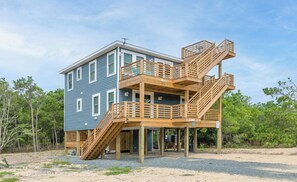 A two-story house with a wooden deck and a staircase. - The Fourth Watch - 4x4 Carova Beach, Ocean View, Brand New, Linens, Flex Stays (Carova Beach)