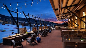 An outdoor seating area with fire pits, tables, and chairs, overlooking a snowy landscape. - TRUE SKI-IN/SKI-OUT Steamboat Springs Resort Villa + Resort Amenities Included (Steamboat Springs)