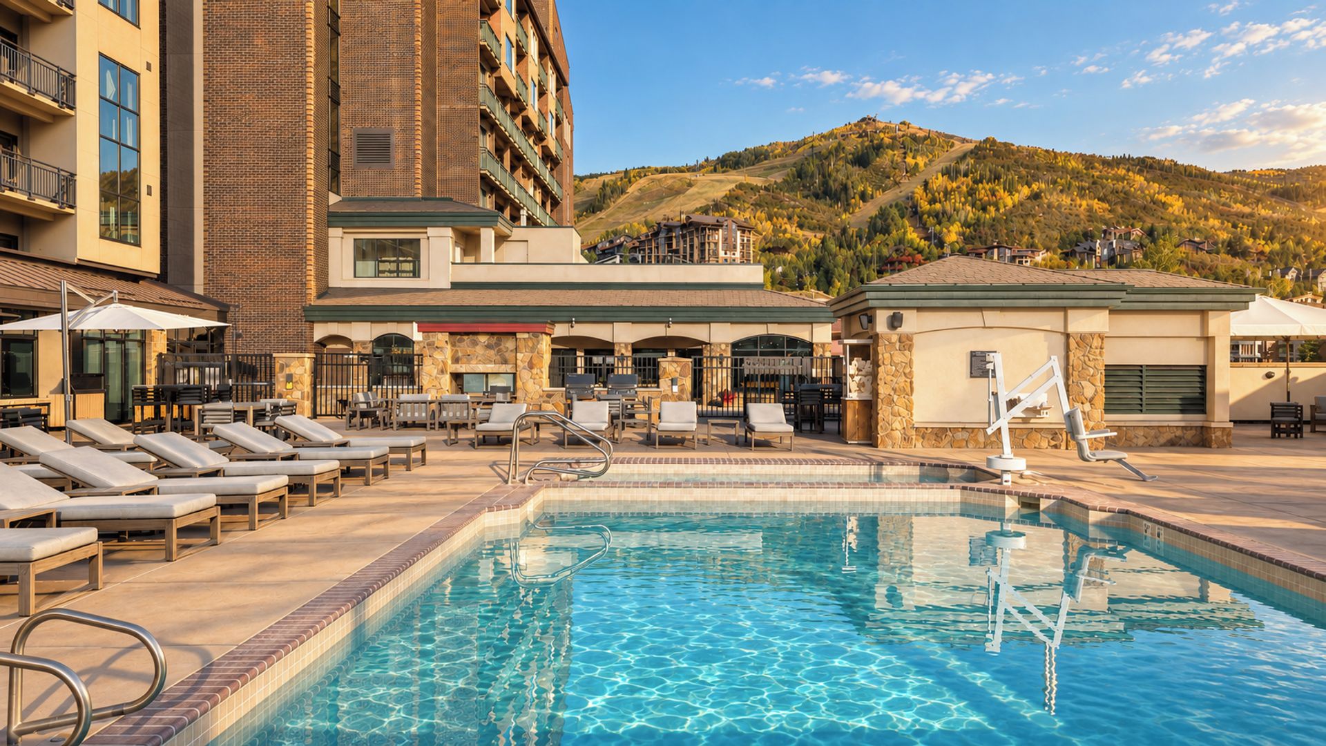 A swimming pool with lounge chairs and a stone building in the background.