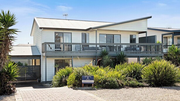 A two-story building with a balcony, surrounded by greenery. - Morrison Shorehouse, Middleton Family Beach House (Middleton)