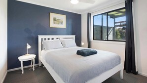 A bedroom with a single bed, a ceiling fan, a window with curtains, and a small bedside table with a lamp. - Morrison Shorehouse, Middleton Family Beach House (Middleton)