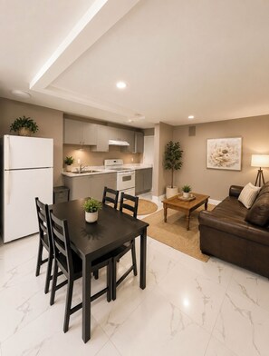 A modern apartment with a dining area, kitchen, and living room. - Ocean Park 2BR Retreat South Surrey & Parking (Surrey)