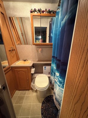 Un baño con inodoro, lavamanos y espejo.