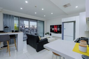 A modern living space with a kitchen, dining area, and a large window.