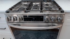 A kitchen with a stainless steel stove, oven, and a white tiled backsplash.