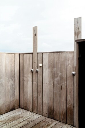 Una terraza de madera con un portón y una puerta de metal.