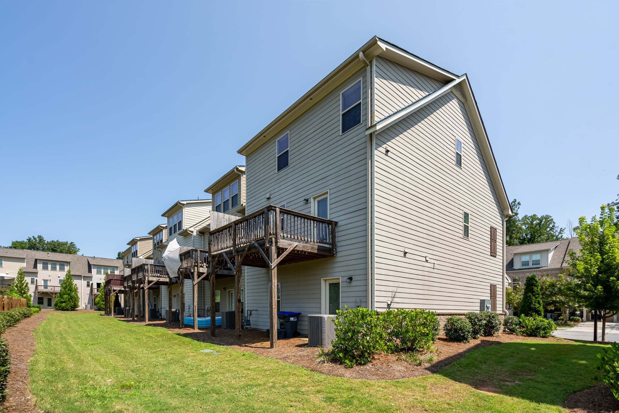 A row of single-story houses with attached porches and a clear sky.