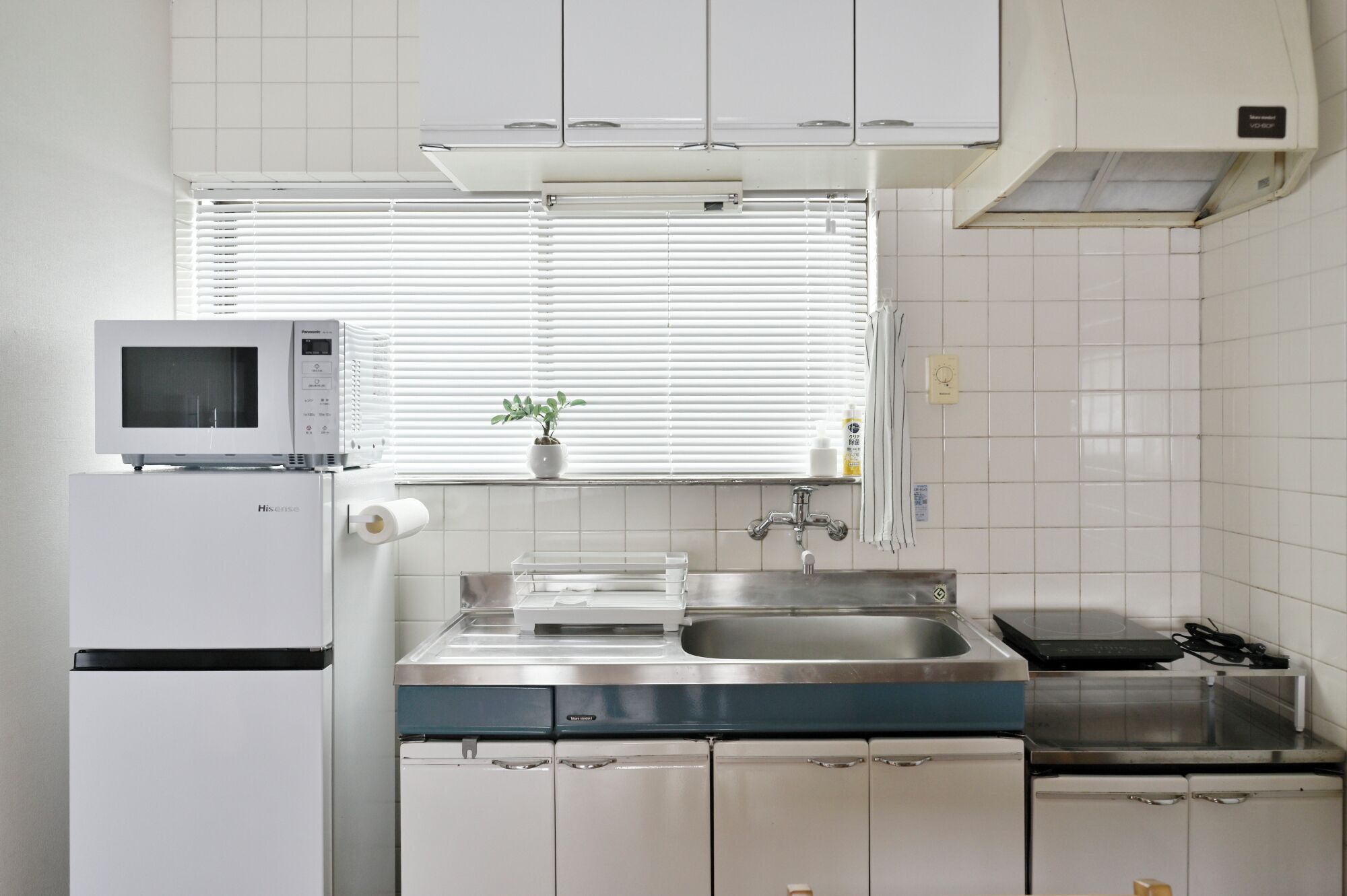 A compact kitchen with a microwave, sink, and stove.