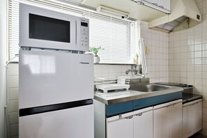 A kitchen with a white refrigerator, a microwave, a sink, and cabinets. - Casa Sun Tsuruhashi | Whole House 1 min to Koreatown, 2BR + Private Rooftop (Osaka)