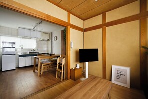 A compact living space with a kitchenette, a dining area, and a television. - Casa Sun Tsuruhashi | Whole House 1 min to Koreatown, 2BR + Private Rooftop (Osaka)