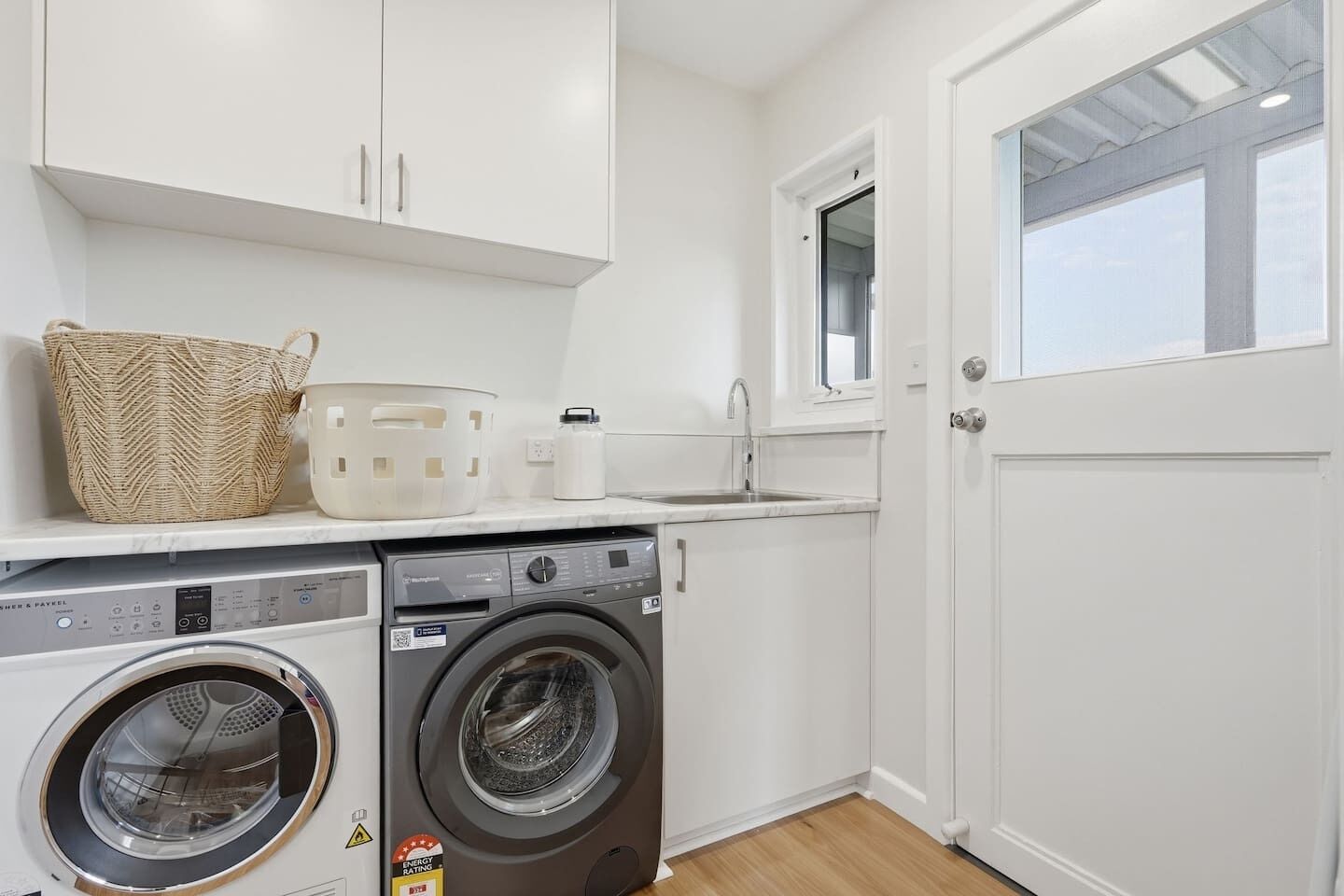 Un cuarto de lavado con lavadora, secadora y lavabo.