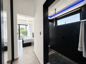 Een moderne badkamer met een douche, een handdoekhouder en een raam.