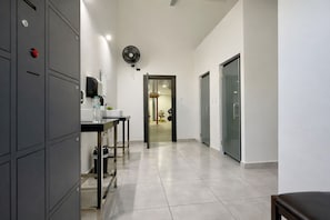 A hallway with lockers, a sink, a fan, and a door leading to another room. - Stylish 1-Bed – LAP Pool - Wi-Fi - GYM - Hot water (Sosúa)