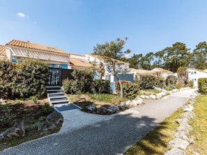 Um bairro residencial com casas, um caminho de cascalho e um portão azul.