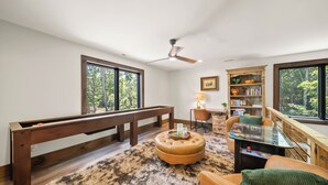 A spacious living room with a pool table, a comfortable seating area, a bookshelf, and large windows offering a view of the outdoors. - Legacy Springs at Eagles Nest - hot tub, creek (Banner Elk)