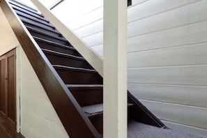 Eine Treppe mit dunkler Metallgeländer und einer hellen Wand.