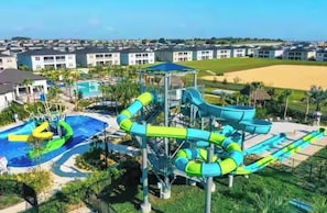 Ein Wasserpark mit mehreren Rutschen und einem Poolbereich, umgeben von Wohngebäuden.
