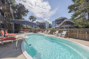 A swimming pool with lounge chairs and a wooden deck. - 1062 - Beach House Blessings Spacious 5BR Corolla retreat with private pool, deck, and elevator. (Corolla)