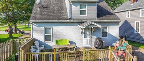 A two-story house with a fenced backyard, a satellite dish, and a chimney.