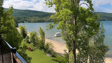 Une vue sur le lac, avec un quai pour bateaux, des pelouses et des arbres.