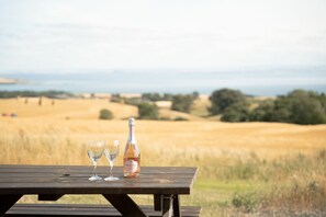Ett picknickbord med två tomma vinglas och en flaska prosecco.