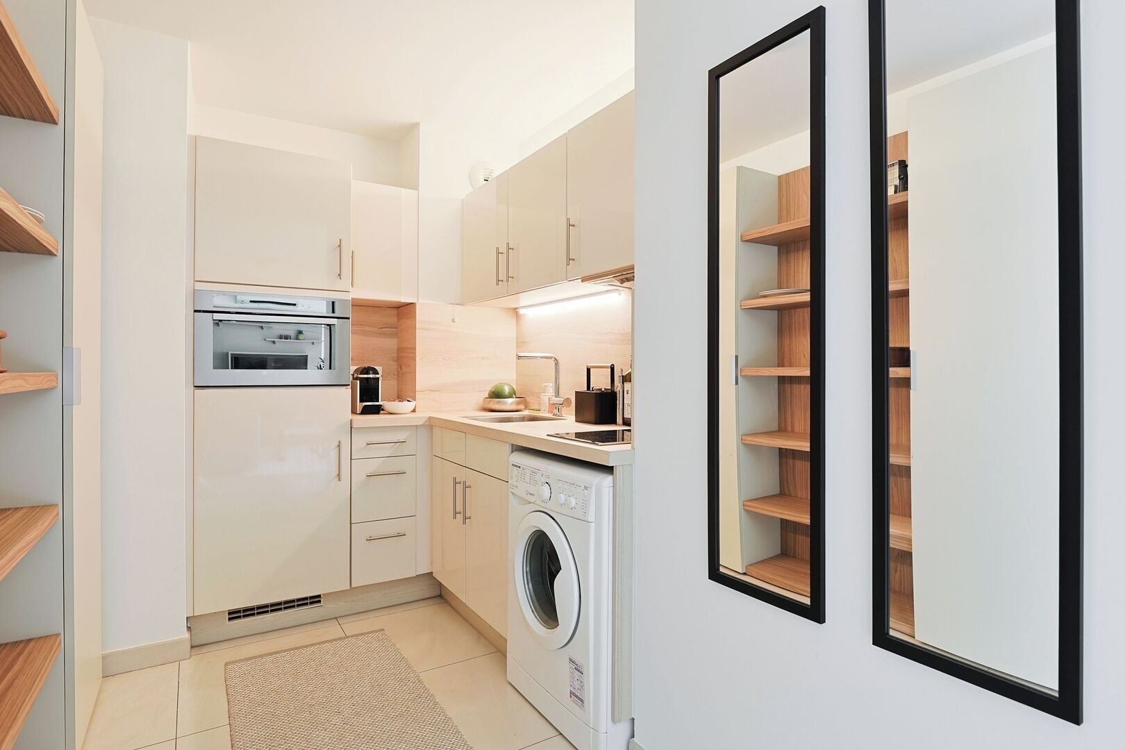 A compact kitchen with a washing machine, a microwave, and a sink.