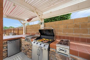 An outdoor kitchen with a grill, a built-in oven, and a refrigerator. - Newell's Nest, Large Pool, Games BBQ Island, 3 bedroom, Outdoor Seating, Parking (Riverside)