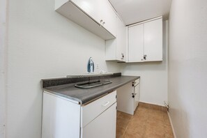 A compact kitchenette with a built-in iron, a sink, and cabinets. - Newell's Nest, Large Pool, Games BBQ Island, 3 bedroom, Outdoor Seating, Parking (Riverside)
