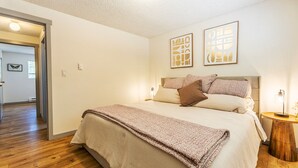 A bedroom with a bed, a bedside table, and two wall art pieces. - Cozy 2 bed - Close to Town  Pet Friendly (Gig Harbor)