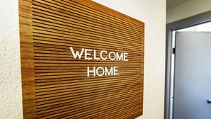 A wooden wall panel with the words "WELCOME HOME" in white letters. - Cozy 2 bed - Close to Town  Pet Friendly (Gig Harbor)