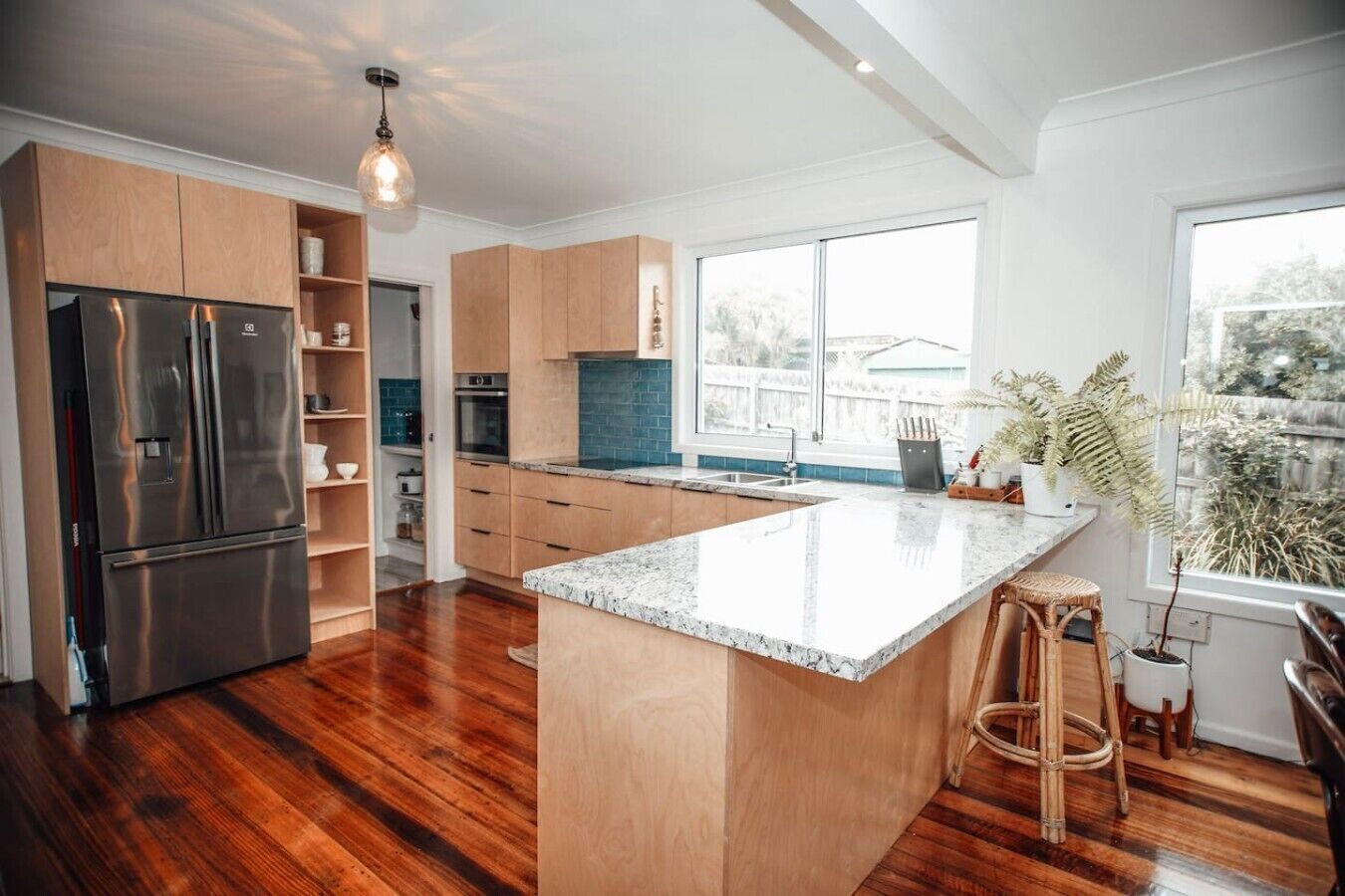 Una cucina moderna con una grande isola, elettrodomestici in acciaio inossidabile e mobili in legno.
