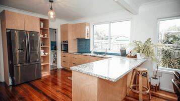 Una cucina moderna con una grande isola, elettrodomestici in acciaio inossidabile e mobili in legno.