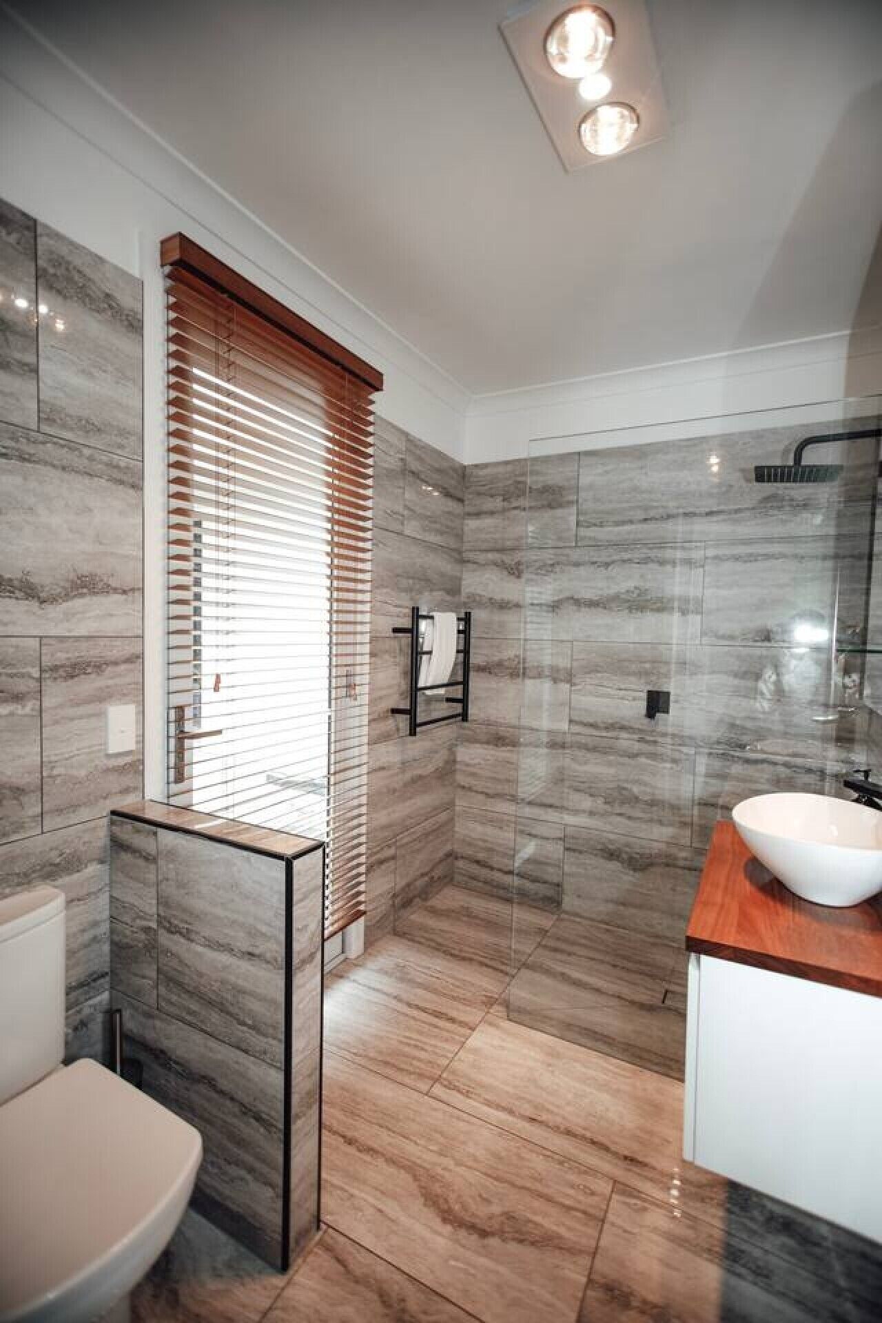 Une salle de bain moderne équipée de toilettes, d’un lavabo et d’un espace douche.