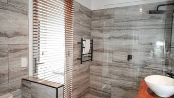 Une salle de bain moderne équipée de toilettes, d’un lavabo et d’un espace douche.