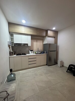 A modern kitchen with a built-in oven, a refrigerator, and a sink. - VIP Family Villa in Juan Dolio (Playa Juan Dolio)