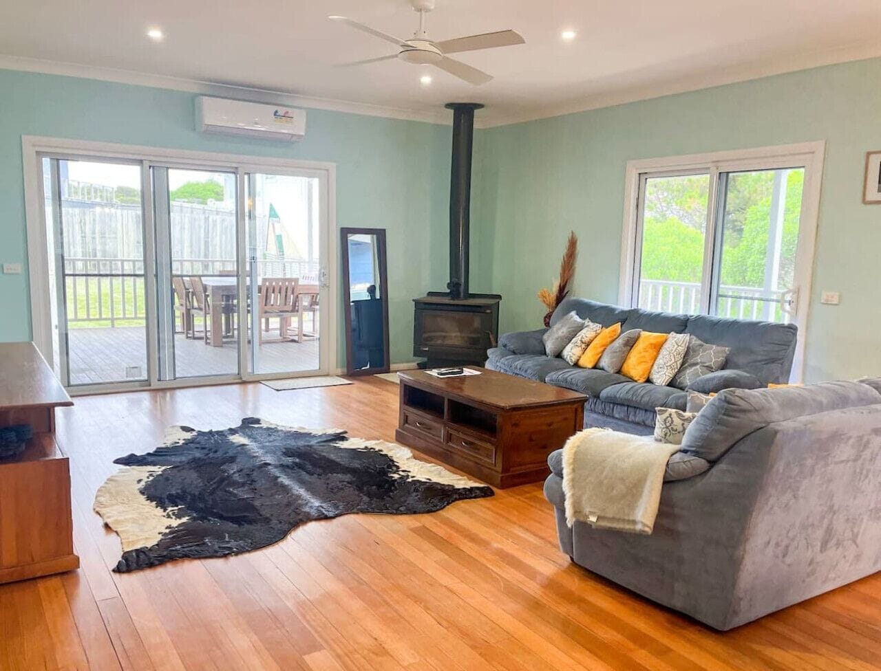 A living room with a sofa, coffee table, and a fireplace.