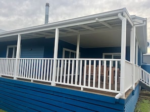 A blue building with a covered porch and white railings. - Seabatical Port Campbell (Port Campbell)