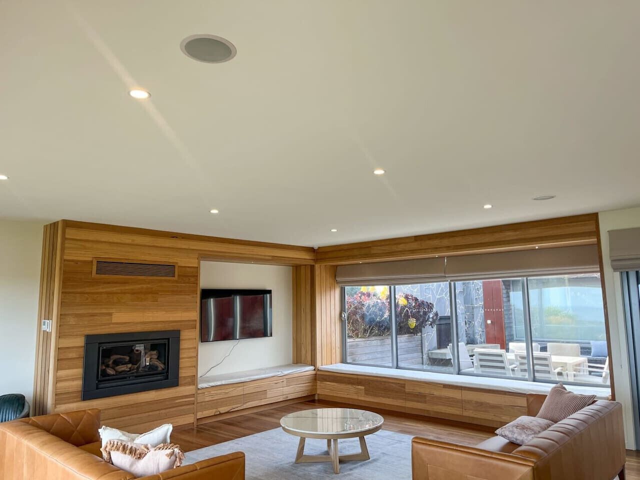 A modern living room with a fireplace, large windows, and a seating area.