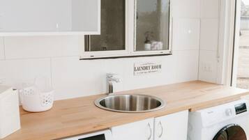 A laundry room with a sink, a washing machine, and a dryer.