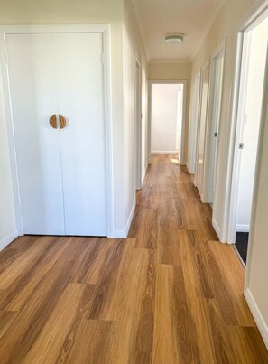 A hallway with wooden flooring and white doors. - Campbell Cottage Port Fairy (Port Fairy)