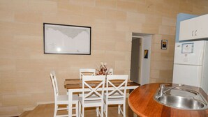 A small kitchenette with a sink, a white refrigerator, and a wooden countertop.