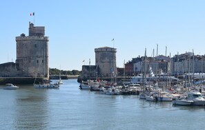 Ein Hafen mit mehreren vertäuten Booten, einem markanten Turm und einem Gebäude mit einer Flagge.