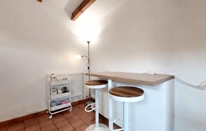 Eine Ecke des Raumes mit einer weißen Heizung, einem weißen Regal und einer weißen Stehlampe.
