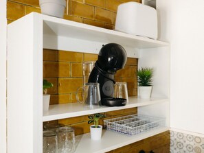 A kitchen shelf with a coffee maker, a glass mug, a small potted plant, and a white container. - Garnacha Harbor's Light (La Vila Joiosa)