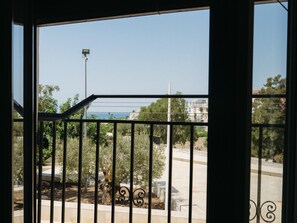 A balcony with a metal railing overlooking a residential area with trees and a clear sky. - Garnacha Harbor's Light (La Vila Joiosa)